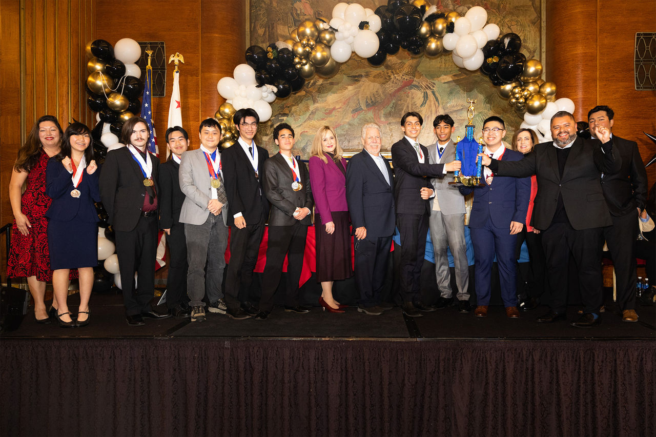 Alhambra High School Academic Decathlon Team on stage holding first place trophy