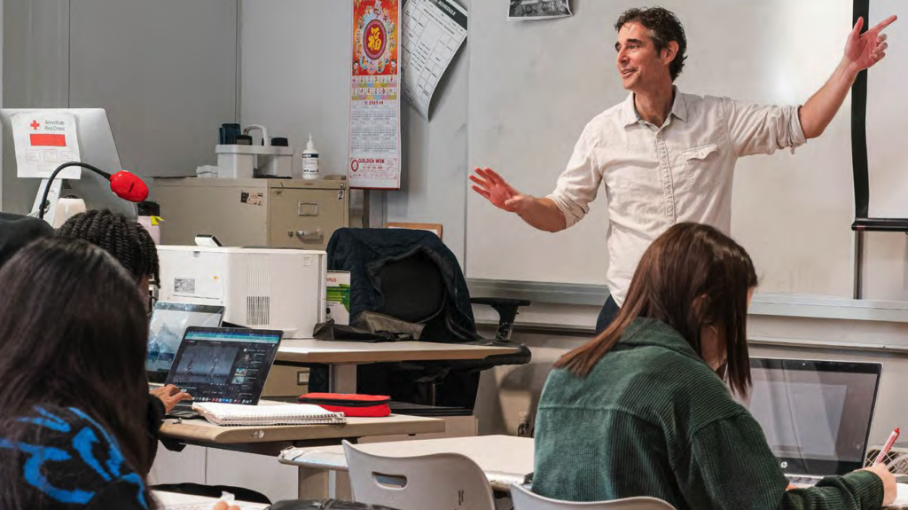 Teacher demonstating in classroom on white board