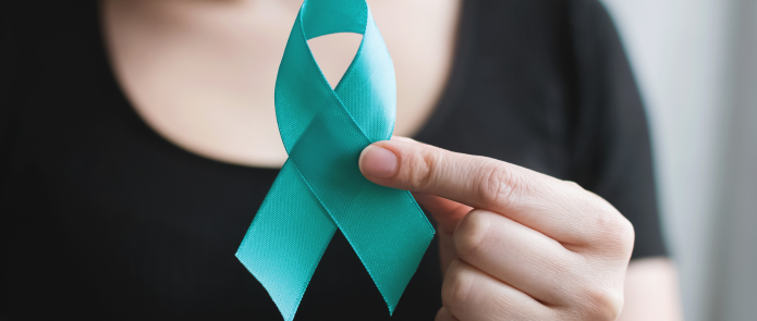 woman holding a teal ribbon