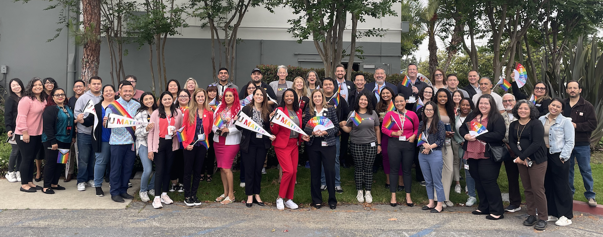 Group of LACOE staff members holding Pride flags