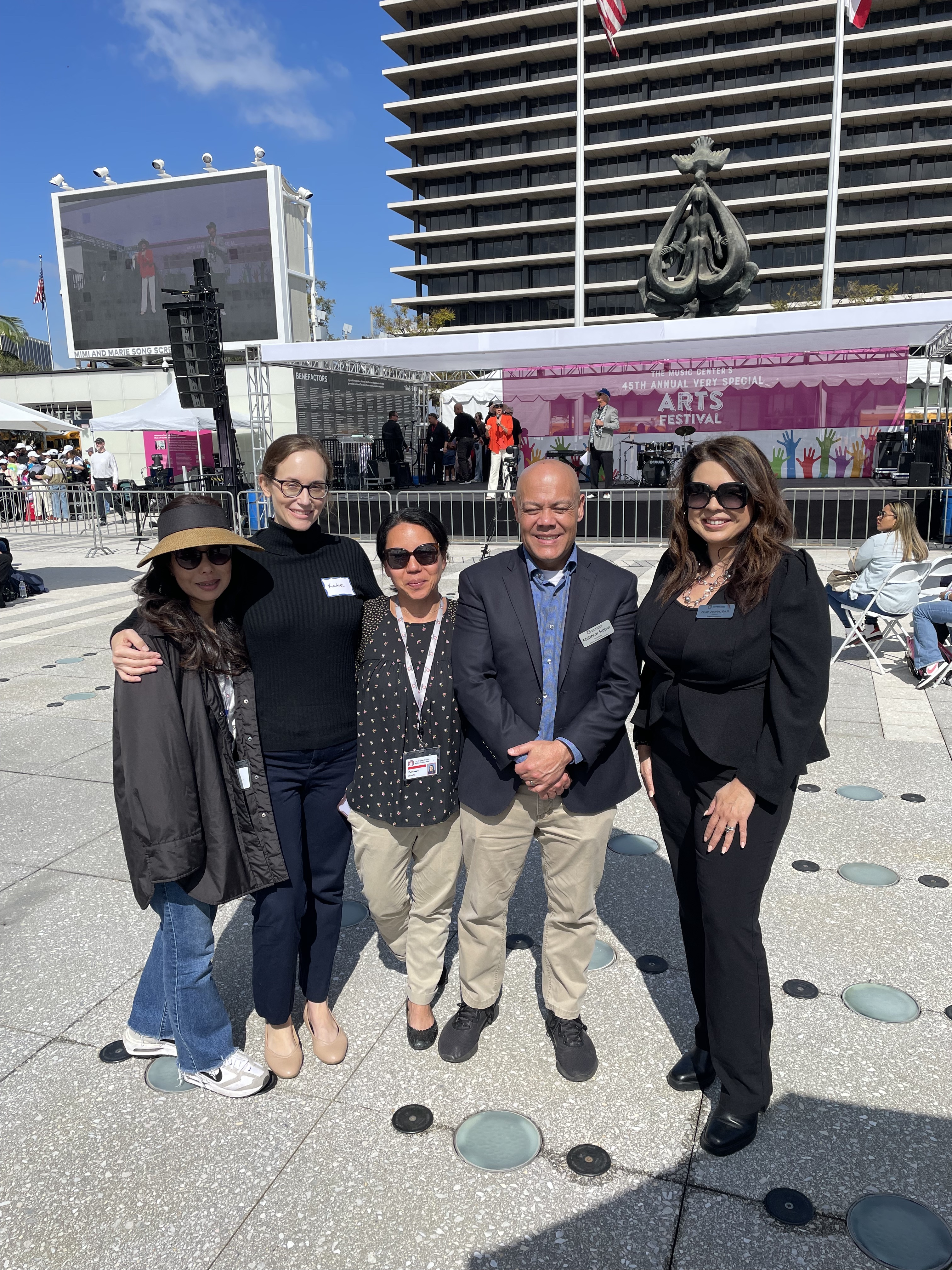 LACOE's Special Education team posing for photo in front of center stage at the festival.