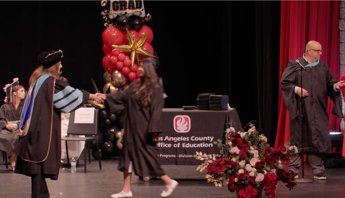 A student shakes hand with Dr. Duardo on stage