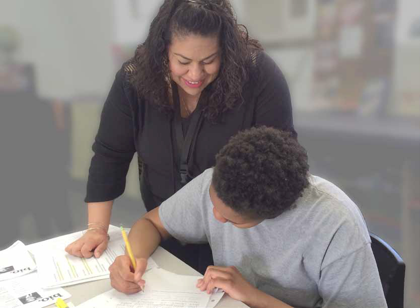 adult helping student with work