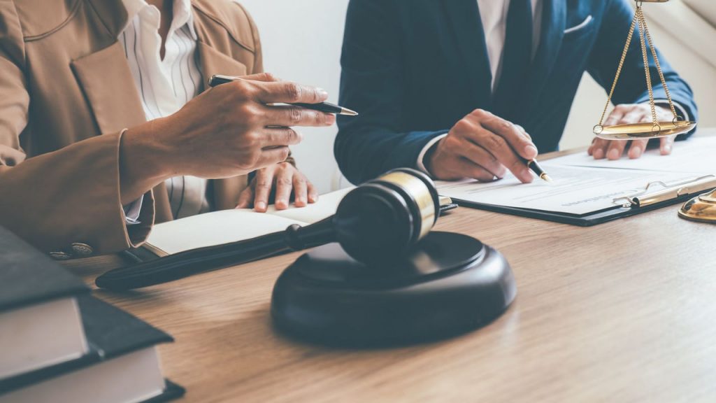 Two people signing forms