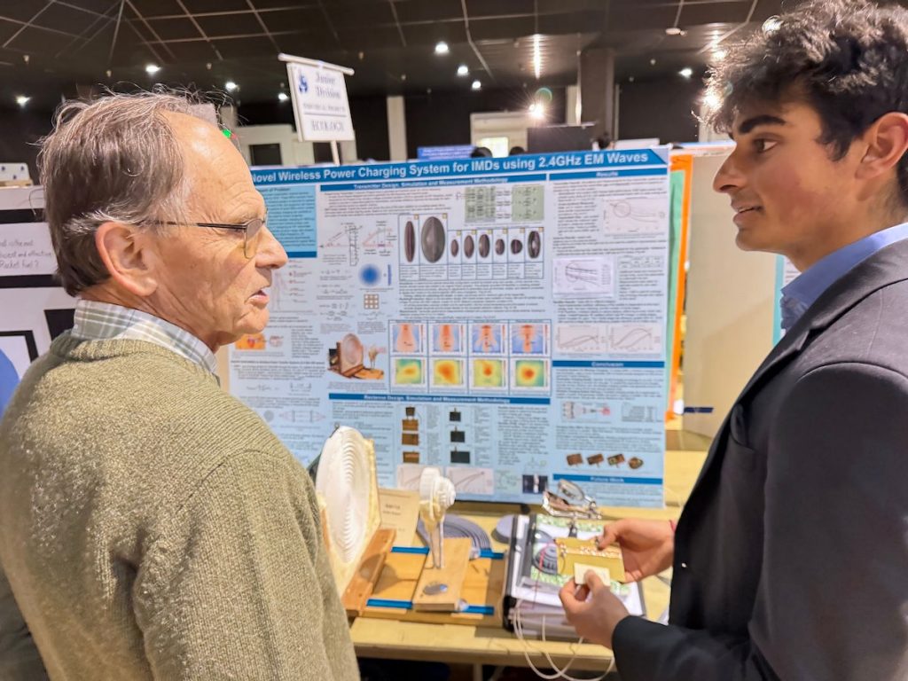 Adult and student in front of science fair project