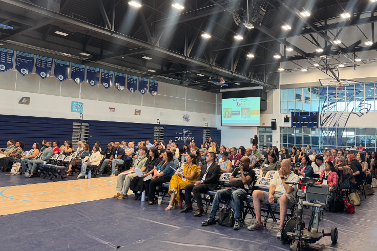 Group of attendees sitting in a gymnasium