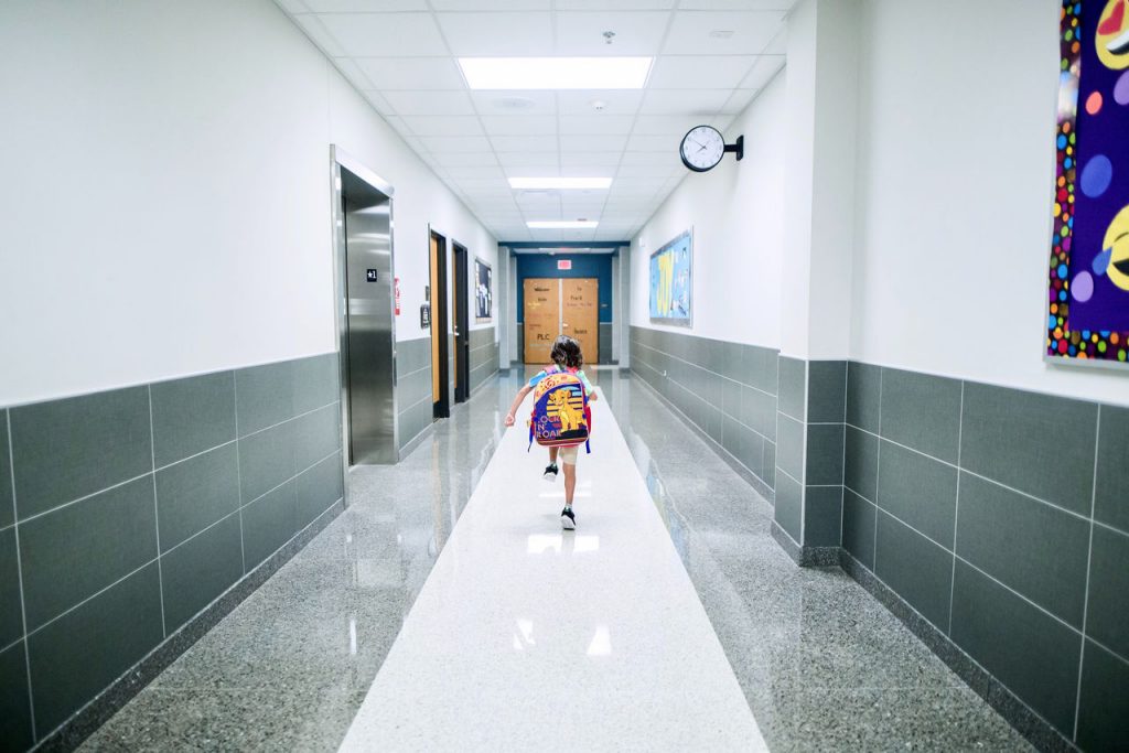 Student walking down an empty school hallway