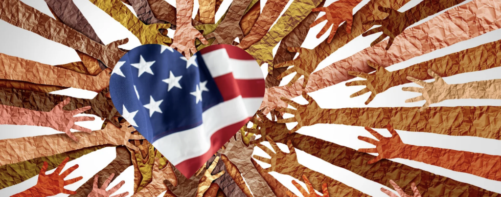 Hands in different shades reaching in to the American flag shaped like a heart.