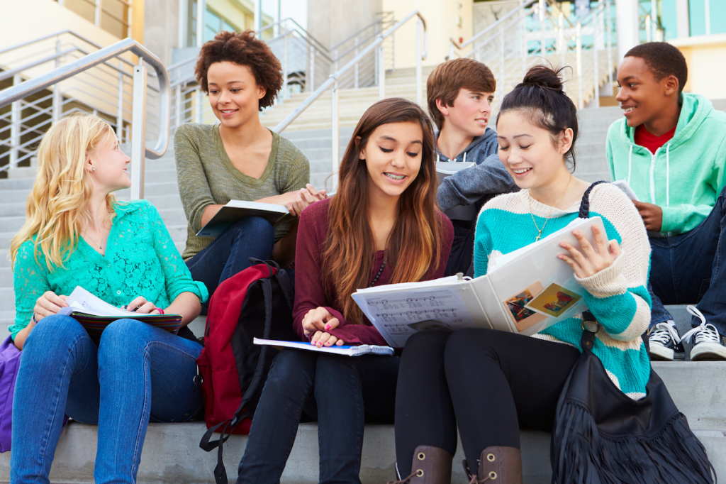 Diverse group of students studying on school stairs