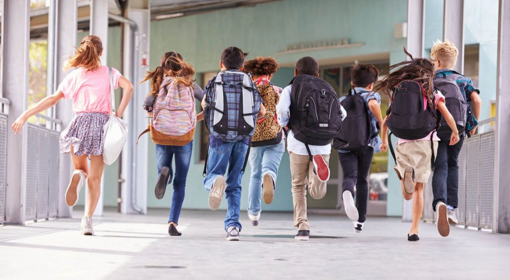 Students running in school hallways wearing backpacks