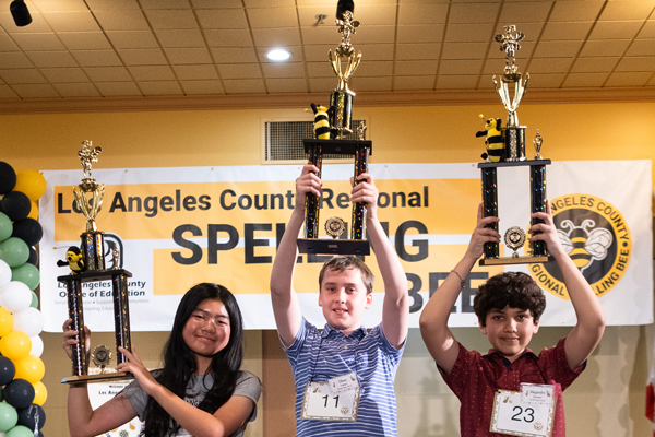 Students holding up Spelling Bee trophies