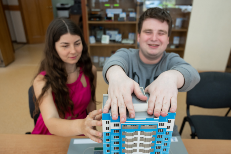 Visually impaired student and aid playing with a toy