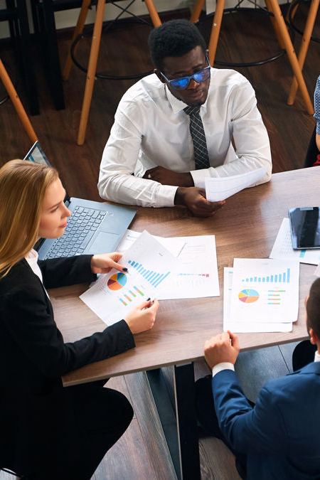 Group huddled around a table holding papers with data