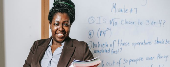 Teacher hold book standing in front of white board