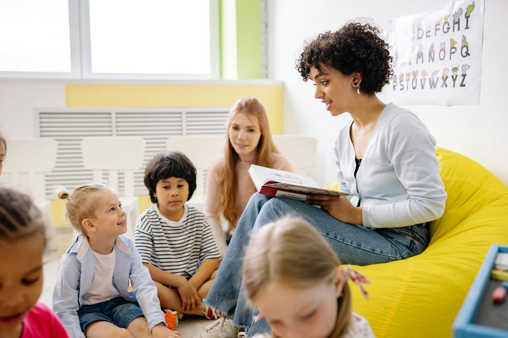 Teacher reading a book to an elementary class