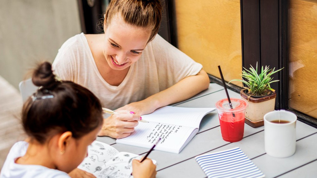 Photo of woman tutoring a young female child