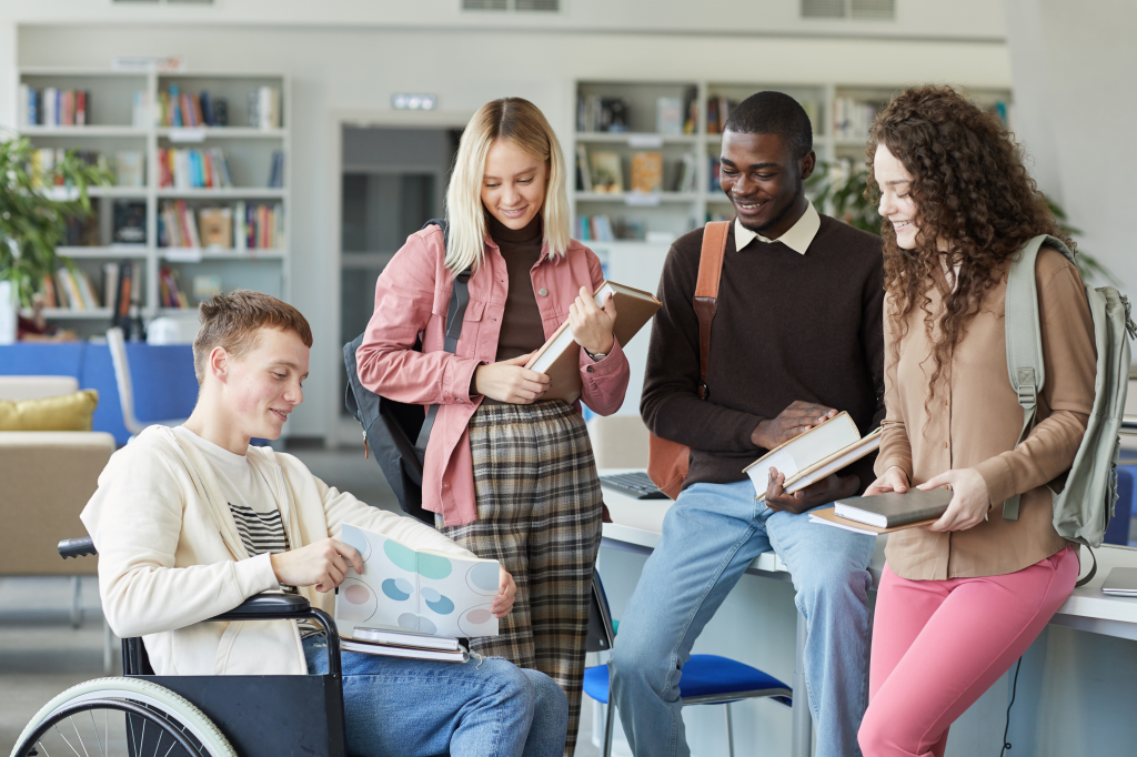 Student is a wheelchair sharing notes with a group of students