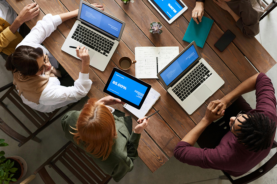 Overhead shot of people on laptops and conversing